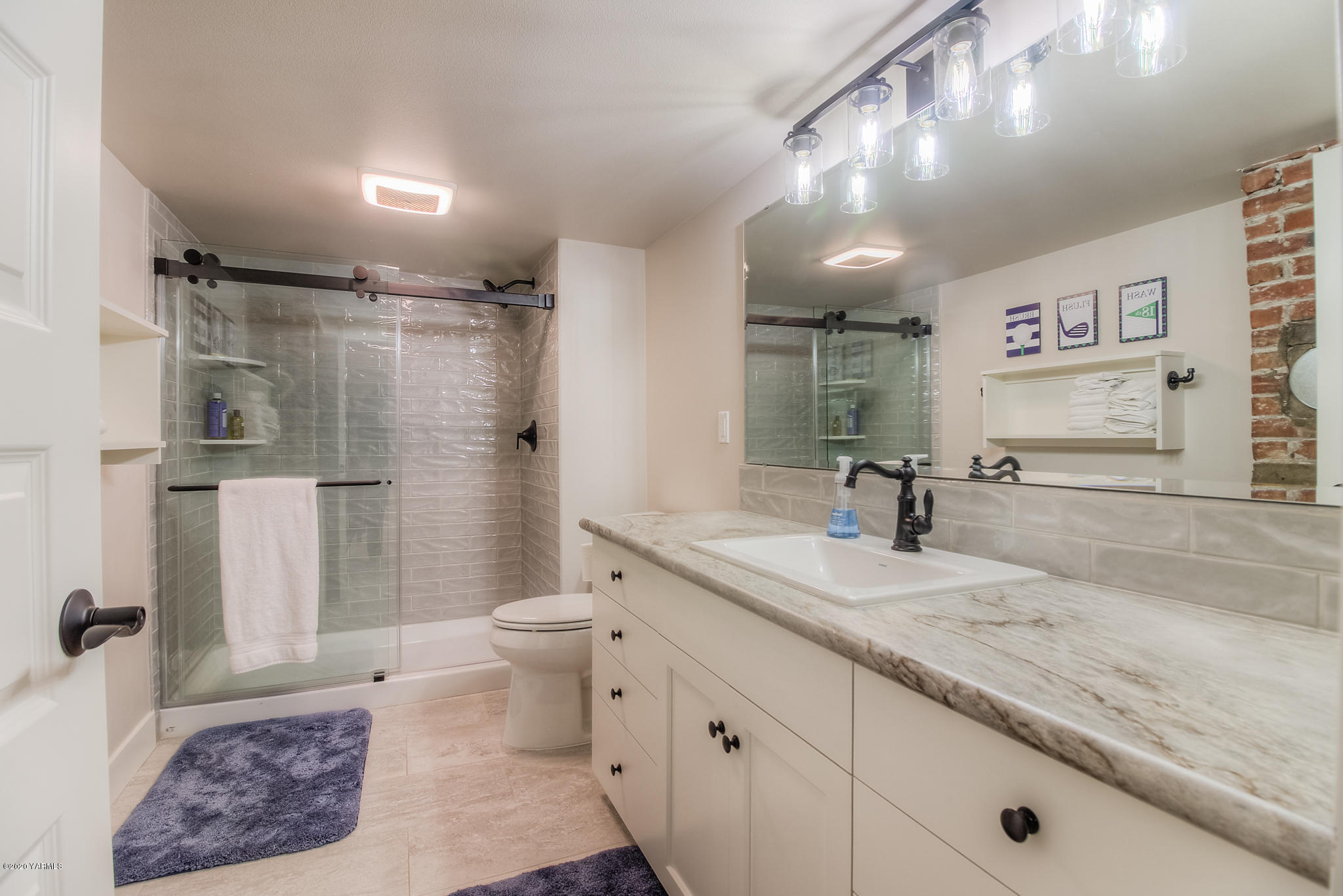 791 Becker Road Toppenish, WA 98948 - Photo 61 of 78 a spacious bathroom with a granite countertop sink a toilet a mirror a vanity and shower