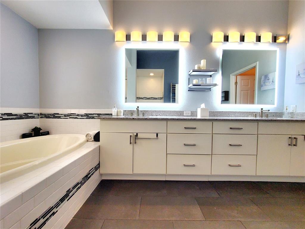 10004 Tree Tops Lake Road Tampa, FL 33626 - Photo 29 of 74 a spacious bathroom with a double vanity sink a mirror and a bathtub