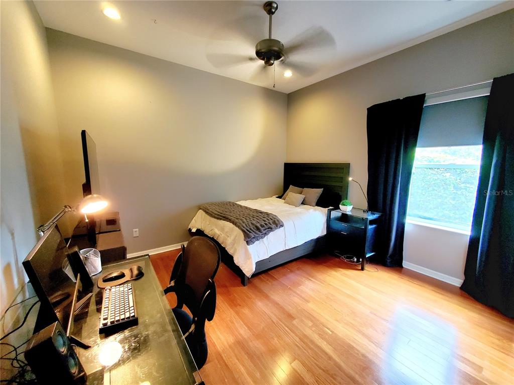 10004 Tree Tops Lake Road Tampa, FL 33626 - Photo 36 of 74 a bedroom with a bed and wooden floor