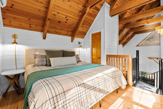 a bedroom with a bed next to a window