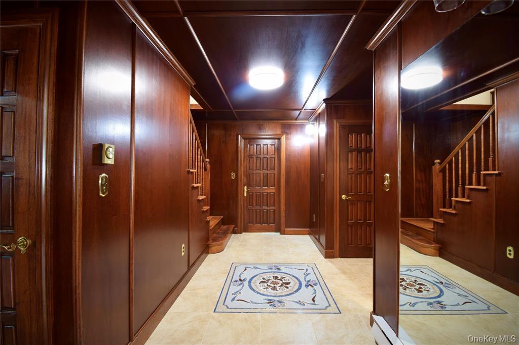 285 Goff Road Livingston Manor, NY 12758 - Photo 3 of 24 Corridor with stairs, woodwalls, and light tile patternedfloors