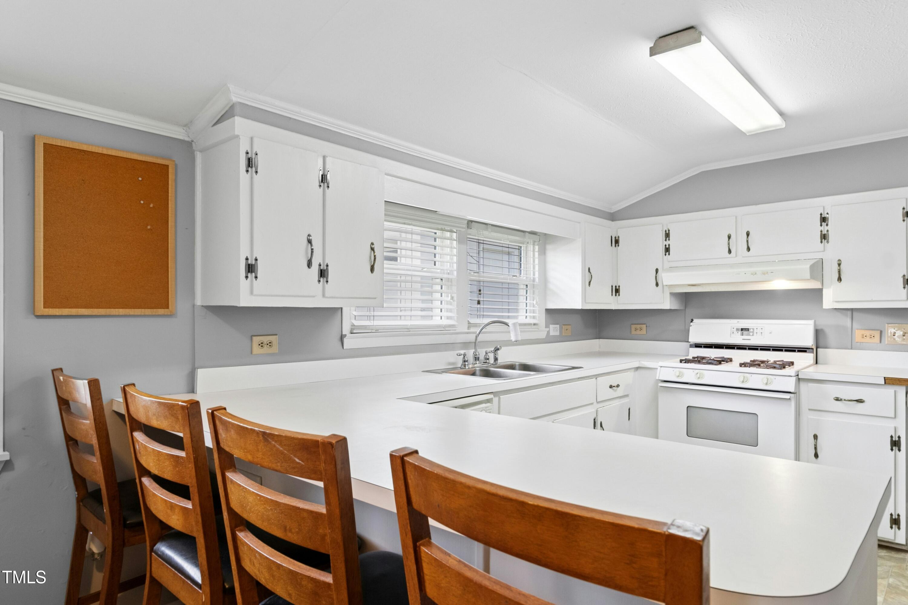 302 North 13th Street Erwin, NC 28339 - Photo 11 of 21 a kitchen with stainless steel appliances granite countertop a white cabinets and wooden floor
