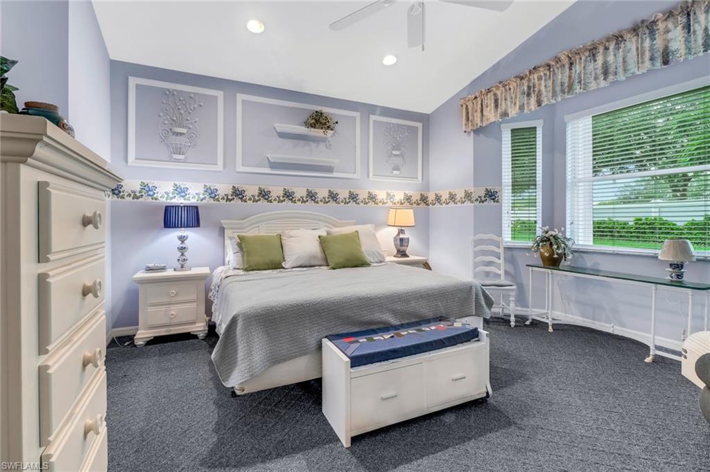 9054 Springview Loop Estero, FL 33928 - Photo 11 of 24 a spacious bedroom with a bed and a chandelier