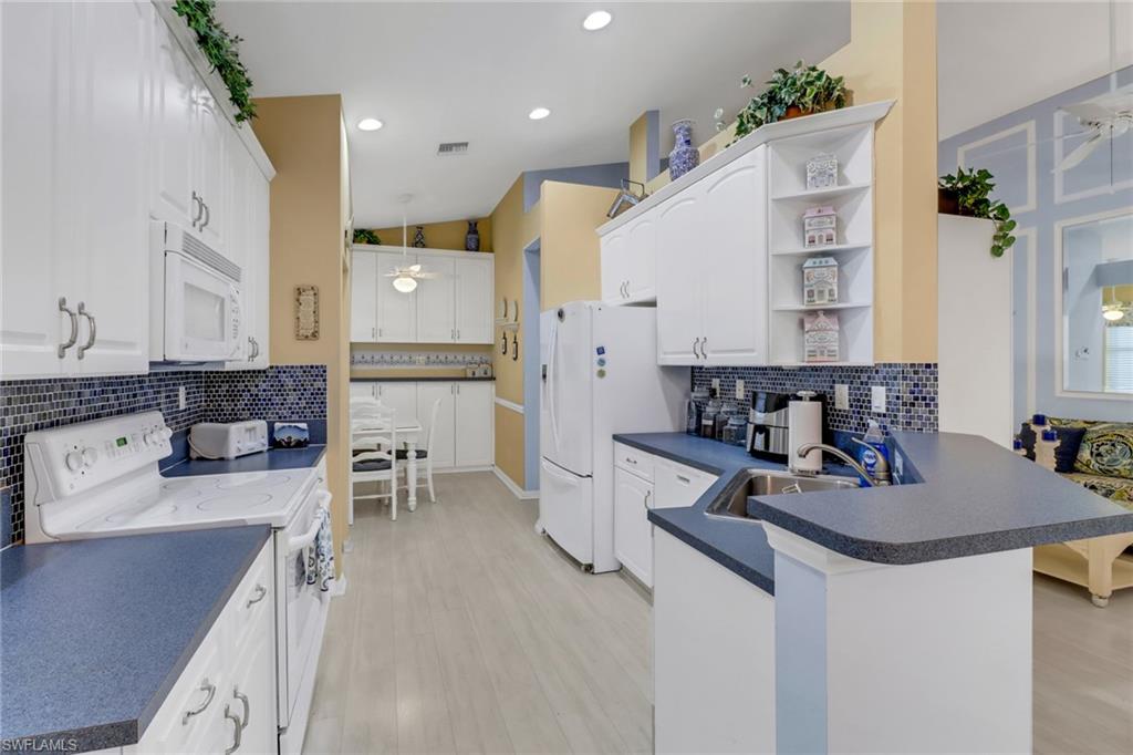 9054 Springview Loop Estero, FL 33928 - Photo 8 of 24 a kitchen with stainless steel appliances kitchen island granite countertop a sink and stove