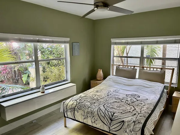 a bedroom with a bed and a large window