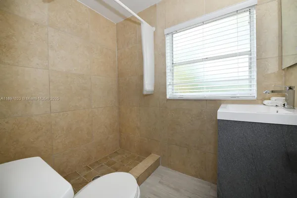 a bathroom with a sink toilet and window