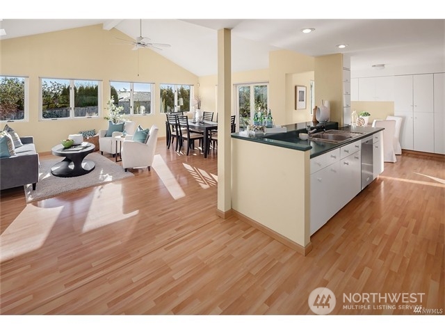 9631 Hilltop Road Bellevue, WA 98004 - Photo 6 of 17 a kitchen with stainless steel appliances kitchen island granite countertop a stove a refrigerator a sink and a dining table with wooden floor