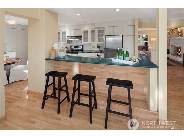 9631 Hilltop Road Bellevue, WA 98004 - Photo 8 of 17 a kitchen with stainless steel appliances kitchen island granite countertop a table and chairs in it