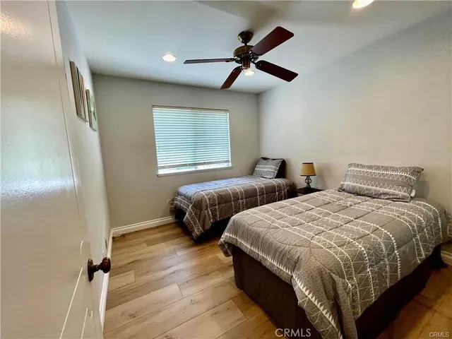 a bedroom with two beds and a ceiling fan