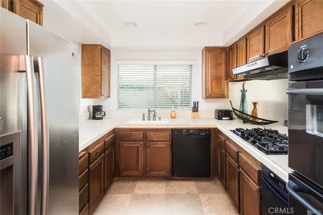 a kitchen with stainless steel appliances granite countertop a stove a refrigerator and a sink
