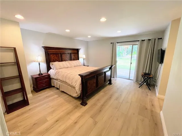 a spacious bedroom with a bed and a dresser in it