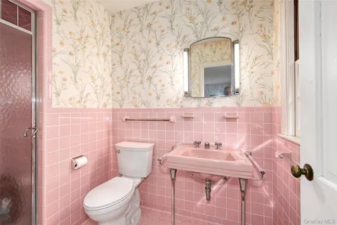 a white toilet sitting next to a bathroom sink