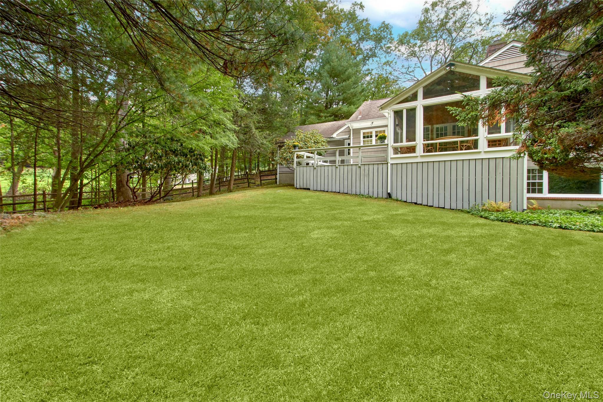 71 Commodore Road Chappaqua, NY 10514 - Photo 31 of 39 a view of a house with a yard and fence
