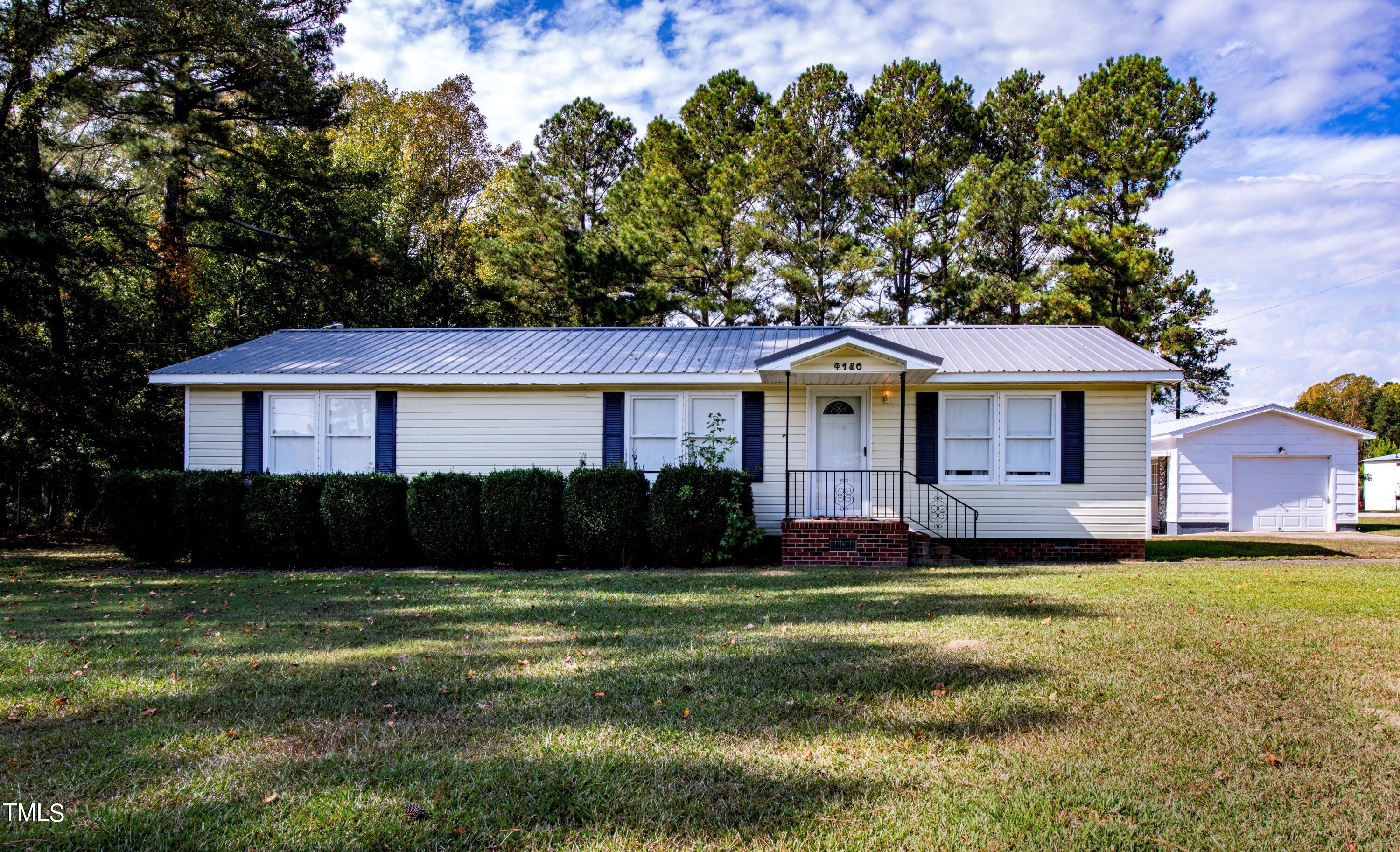 4180 Brantley Road Zebulon, NC 27597 - Photo 1 of 15 a front view of a house with a yard and garage