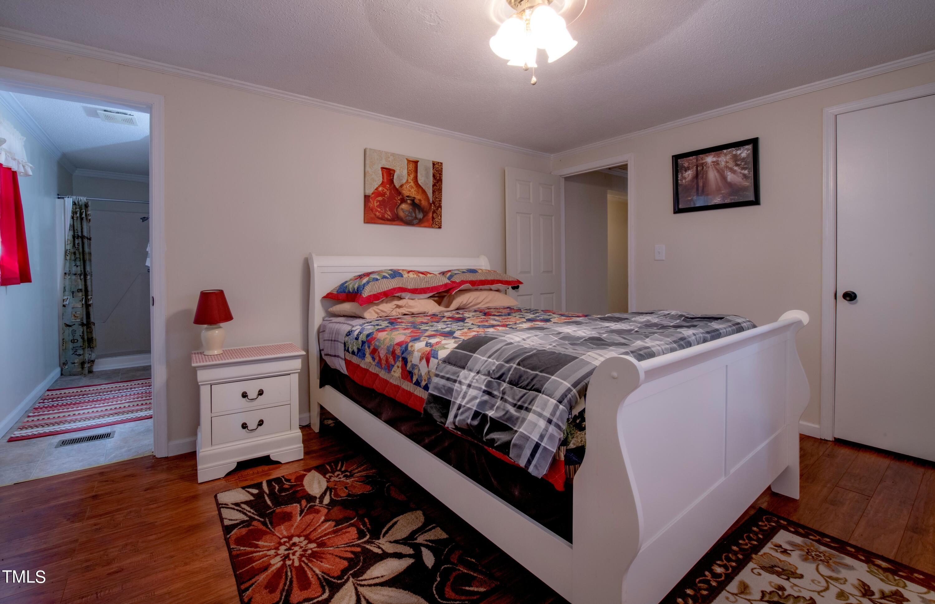 4180 Brantley Road Zebulon, NC 27597 - Photo 9 of 15 a bed room with a bed and a chandelier