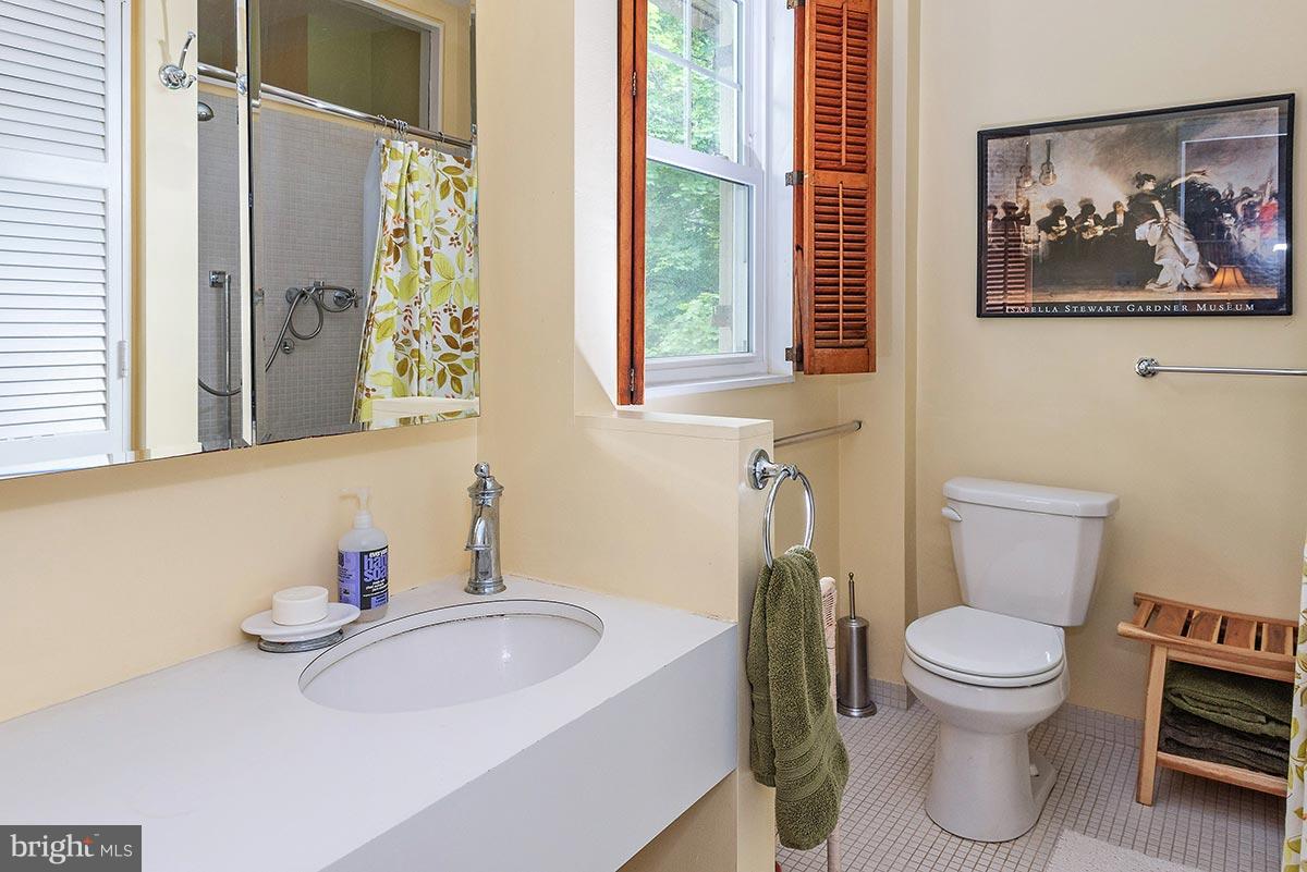 3924 Cloverhill Road Baltimore, MD 21218 - Photo 14 of 30 a bathroom with a toilet a sink and a mirror