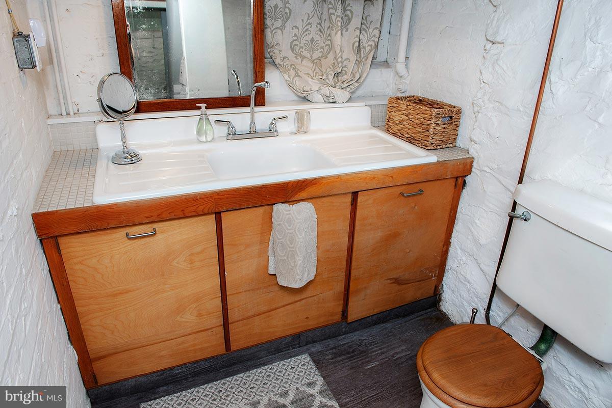 3924 Cloverhill Road Baltimore, MD 21218 - Photo 22 of 30 a bathroom with a sink a toilet and mirror