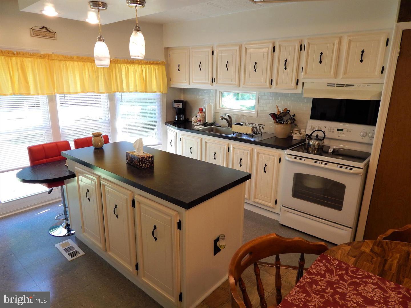 1711 Burkholder Road Red Lion, PA 17356 - Photo 6 of 24 a kitchen with stainless steel appliances granite countertop a stove a sink dishwasher and white cabinets with wooden floor