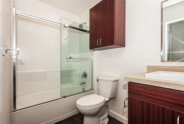 a bathroom with a granite countertop sink toilet and shower