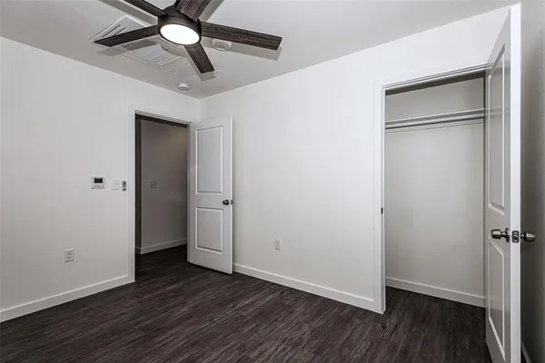 a view of a room with wooden floor and a ceiling fan