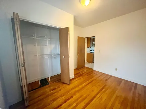a view of empty room with wooden floor