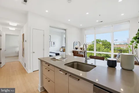 a kitchen with stainless steel appliances a sink a counter top space a large window cabinets and a counter top space