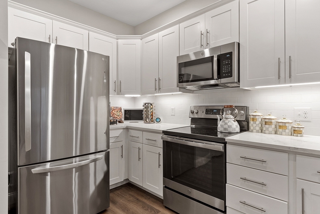 3202 Briarwood Village, Unit 3202 Clinton, MA 01510 - Photo 13 of 35 a kitchen with stainless steel appliances white cabinets white stove a microwave and a refrigerator
