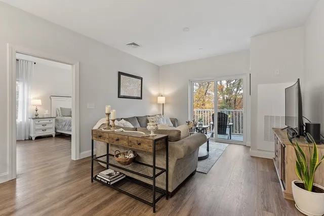 a living room with furniture a flat screen tv and a floor to ceiling window