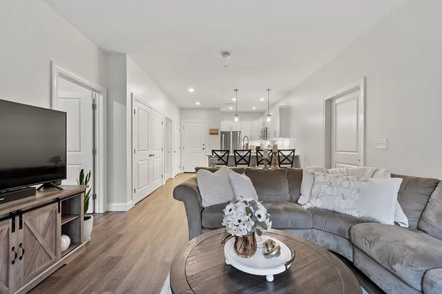 a living room with furniture kitchen view and a flat screen tv
