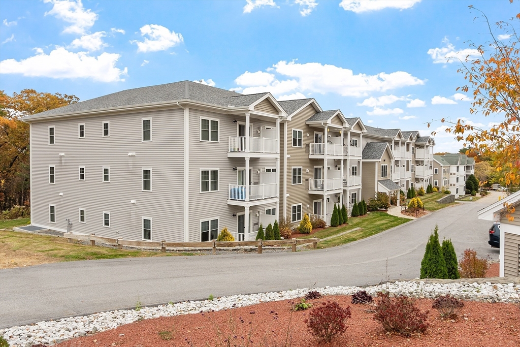 3202 Briarwood Village, Unit 3202 Clinton, MA 01510 - Photo 2 of 35 a view of a white building among the street