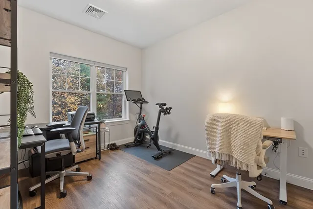 a view of a workspace with furniture and a window