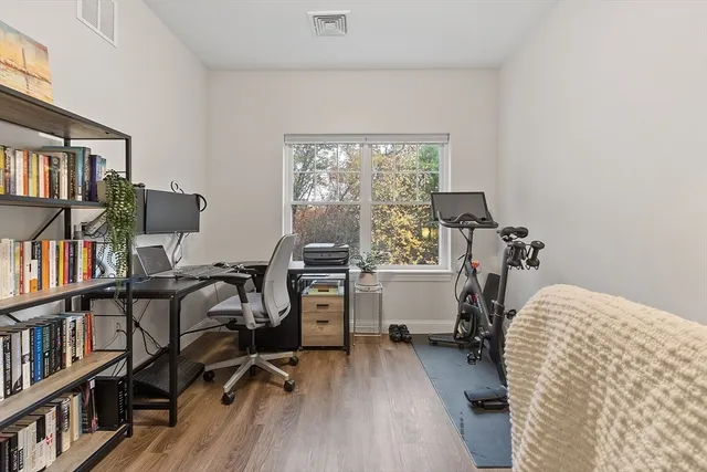 a view of a workspace with furniture and a bookshelf