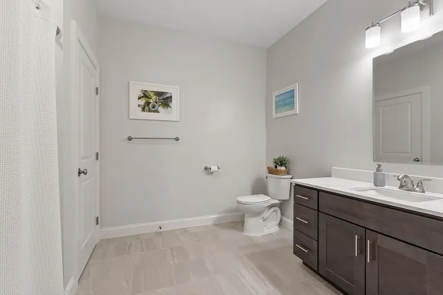a bathroom with a toilet sink vanity and mirror