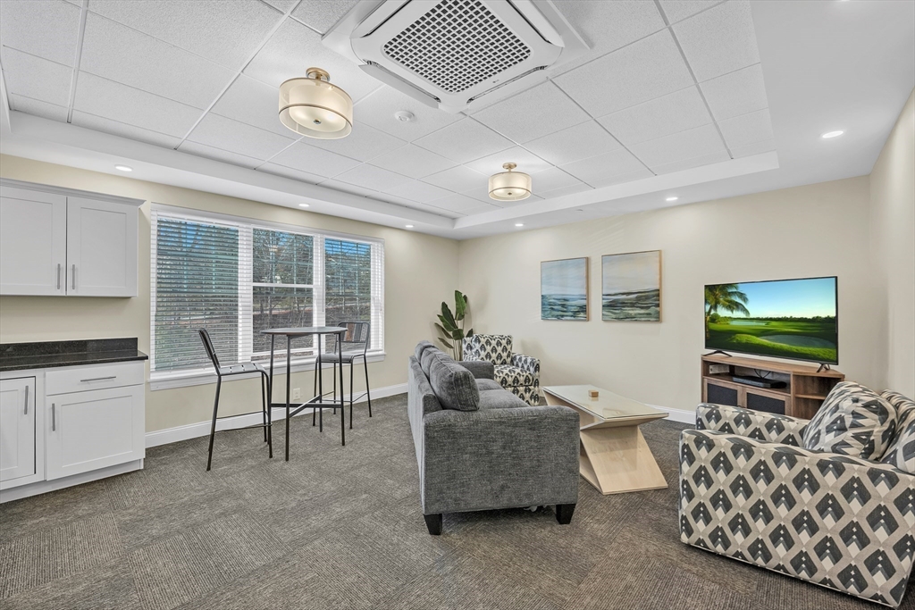3202 Briarwood Village, Unit 3202 Clinton, MA 01510 - Photo 34 of 35 a living room with furniture and a flat screen tv