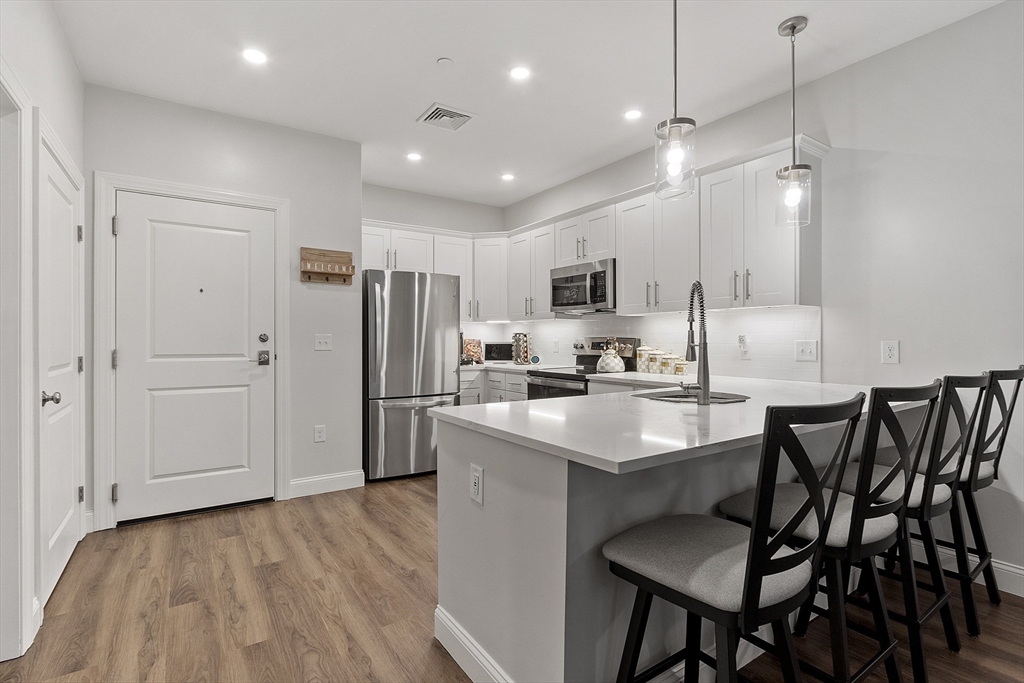 3202 Briarwood Village, Unit 3202 Clinton, MA 01510 - Photo 10 of 35 a kitchen with kitchen island a stove a table and chairs in it