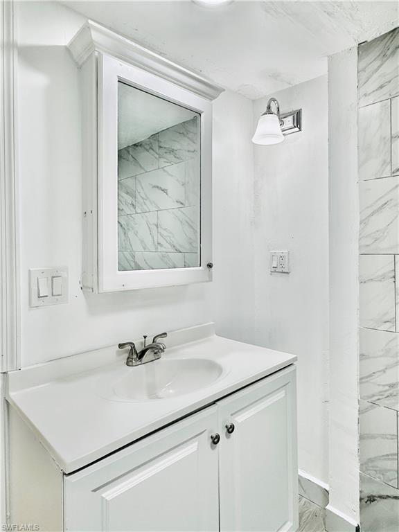 826 Wiggins Pass Road, Unit 307 Naples, FL 34110 - Photo 15 of 17 a bathroom with a sink and a mirror