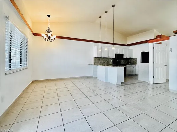 a kitchen with granite countertop white cabinets and stainless steel appliances