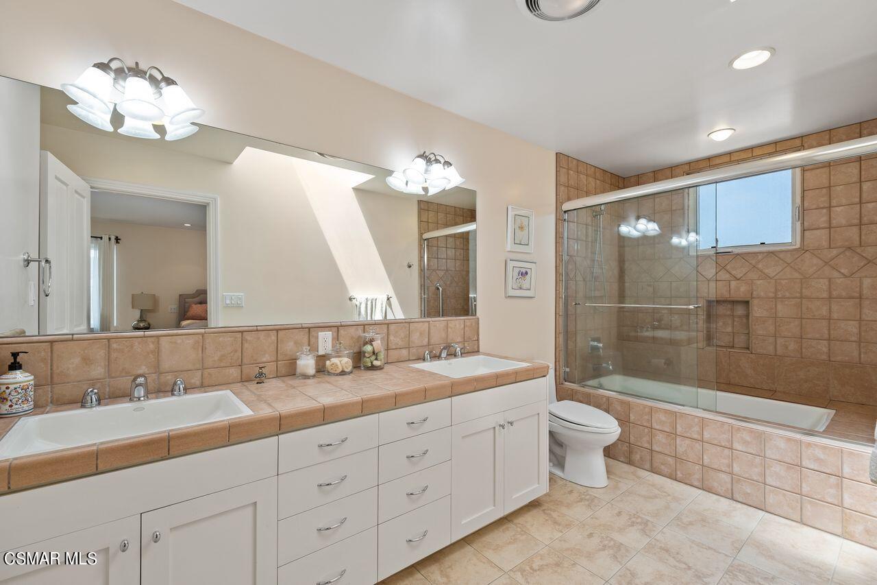 11616 Clarkson Road Los Angeles, CA 90064 - Photo 26 of 34 a spacious bathroom with a double vanity sink a toilet a mirror and shower