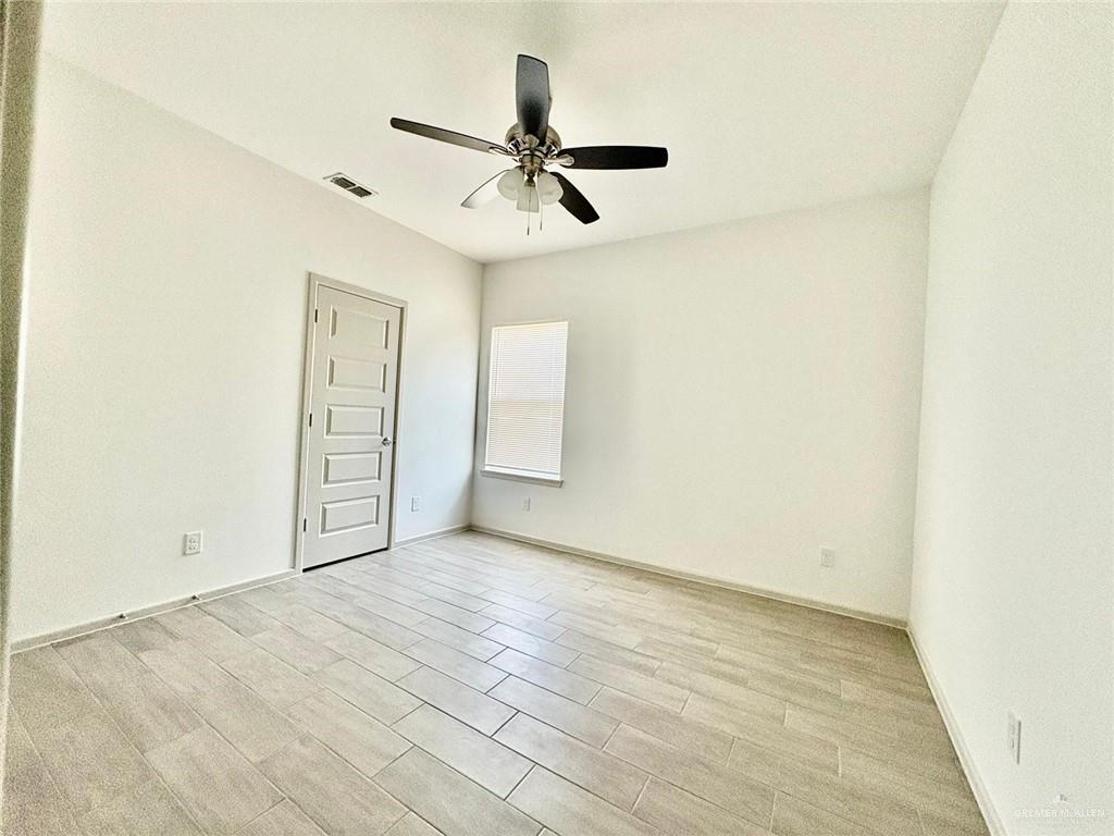 7702 North 58th Street, Unit 3 Mission, TX 78573 - Photo 5 of 11 Unfurnished room with wood finish floors and a ceiling fan