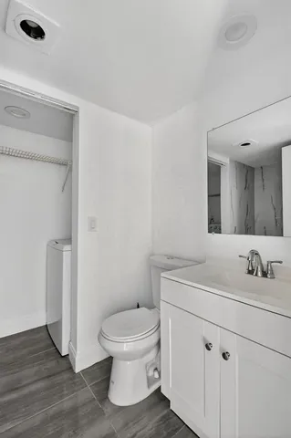 a bathroom with a toilet sink and mirror