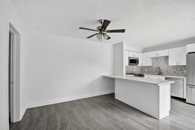 a kitchen with white cabinets and white appliances