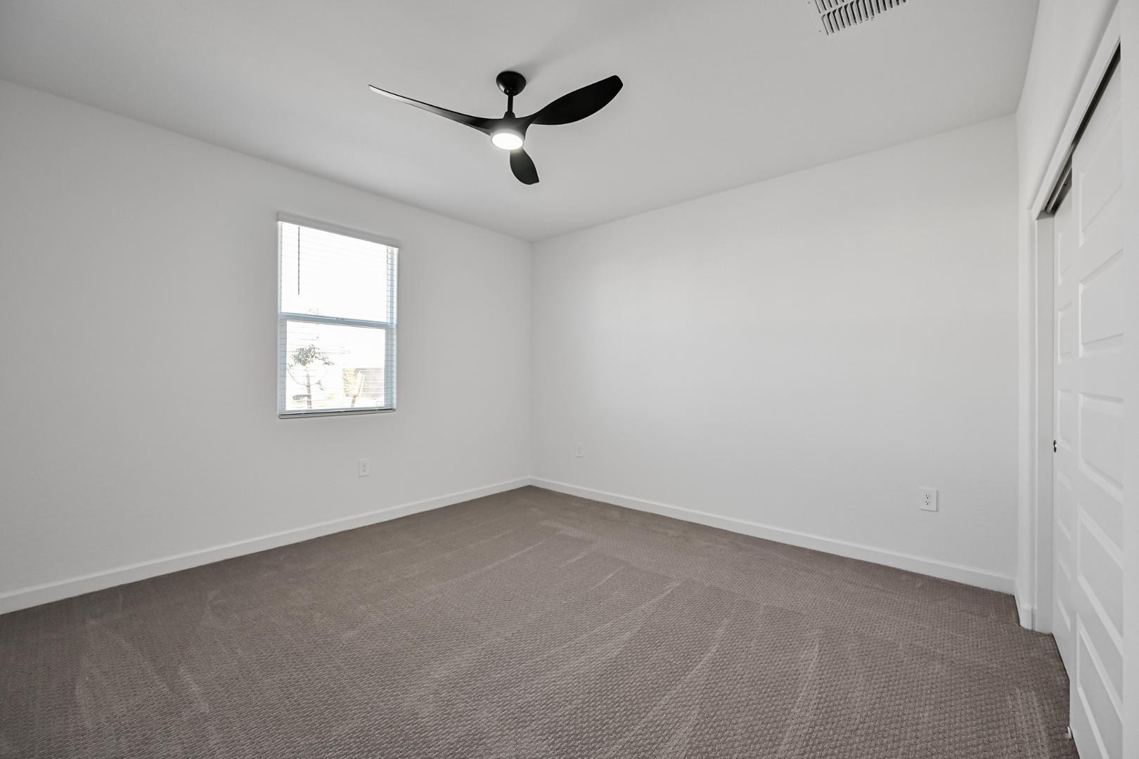2129 West Spaulding Avenue Apache Junction, AZ 85120 - Photo 18 of 28 an empty room with ceiling fan and windows