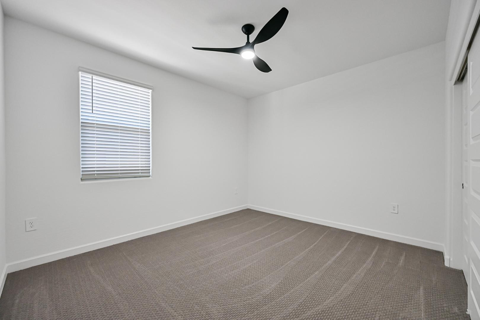 2129 West Spaulding Avenue Apache Junction, AZ 85120 - Photo 22 of 28 an empty room with a window and a fan