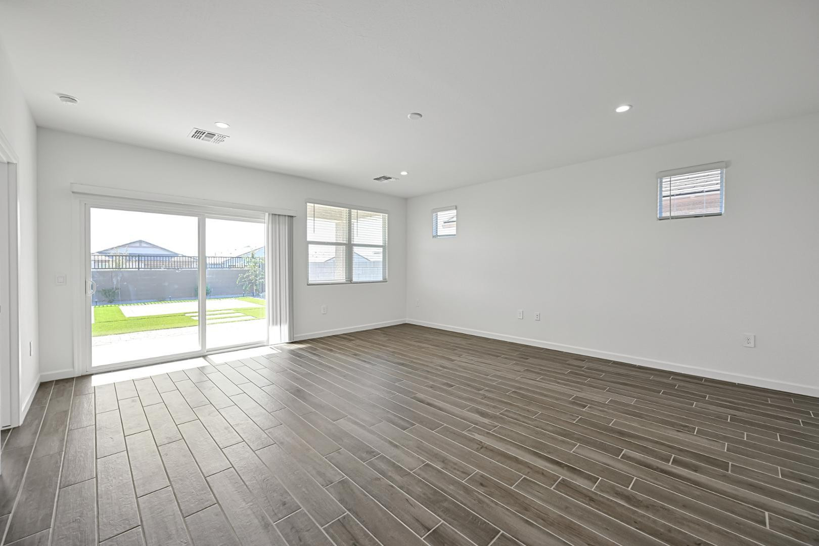 2129 West Spaulding Avenue Apache Junction, AZ 85120 - Photo 4 of 28 a view of an empty room with wooden floor and a window