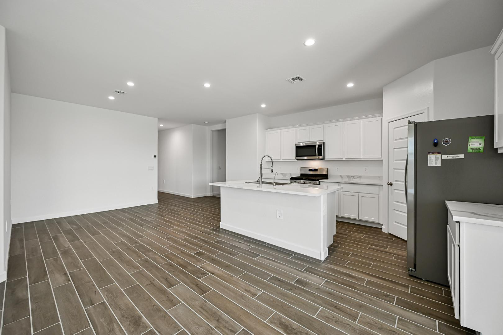 2129 West Spaulding Avenue Apache Junction, AZ 85120 - Photo 7 of 28 a kitchen with a refrigerator and white cabinets