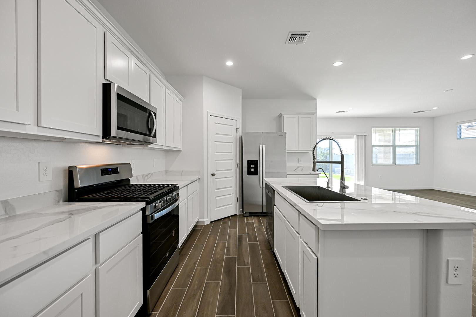 2129 West Spaulding Avenue Apache Junction, AZ 85120 - Photo 9 of 28 a kitchen with granite countertop a sink and a stove top oven