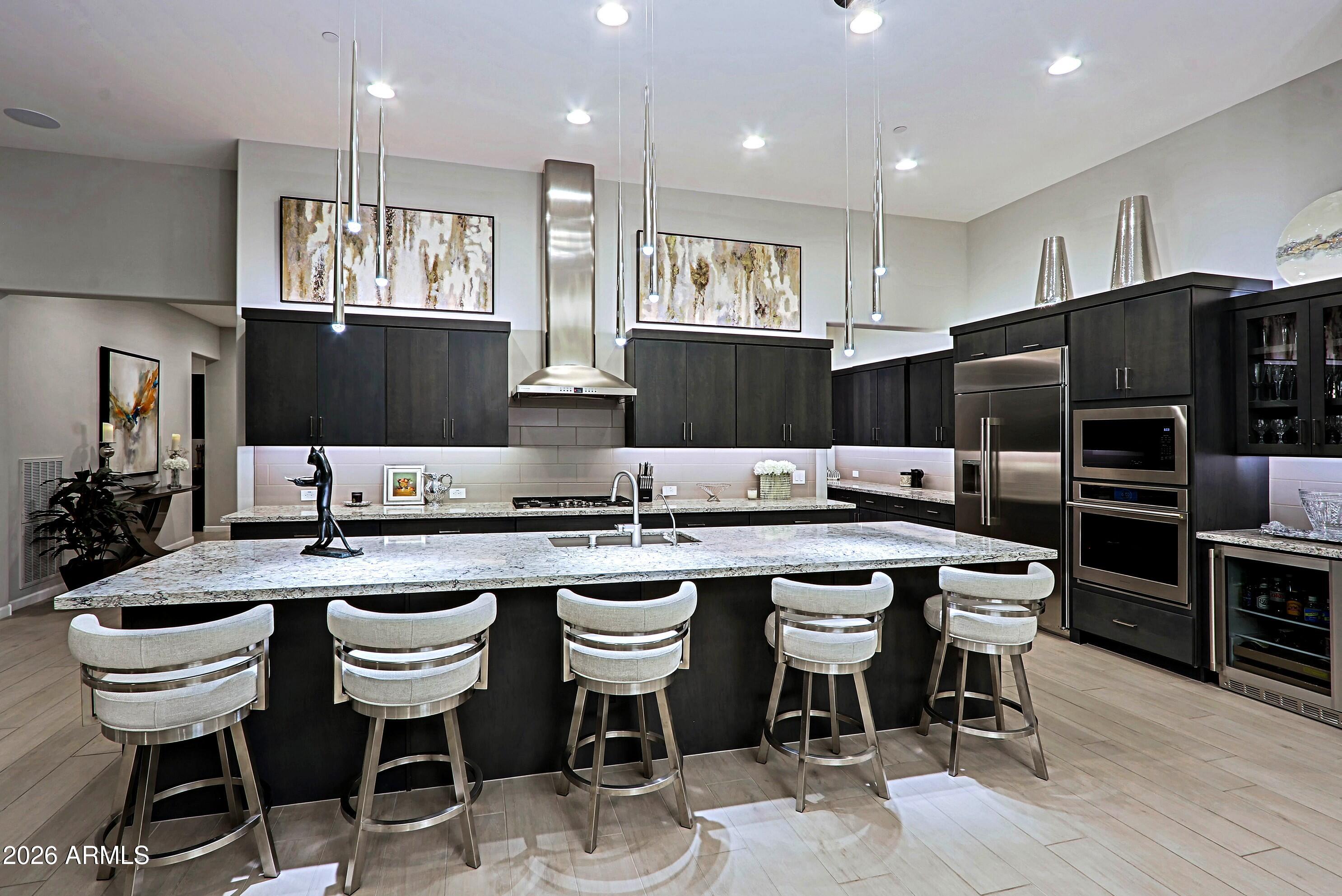 17864 East Paria Canyon Drive Rio Verde, AZ 85263 - Photo 13 of 66 a kitchen with stainless steel appliances kitchen island granite countertop a dining table chairs and a refrigerator