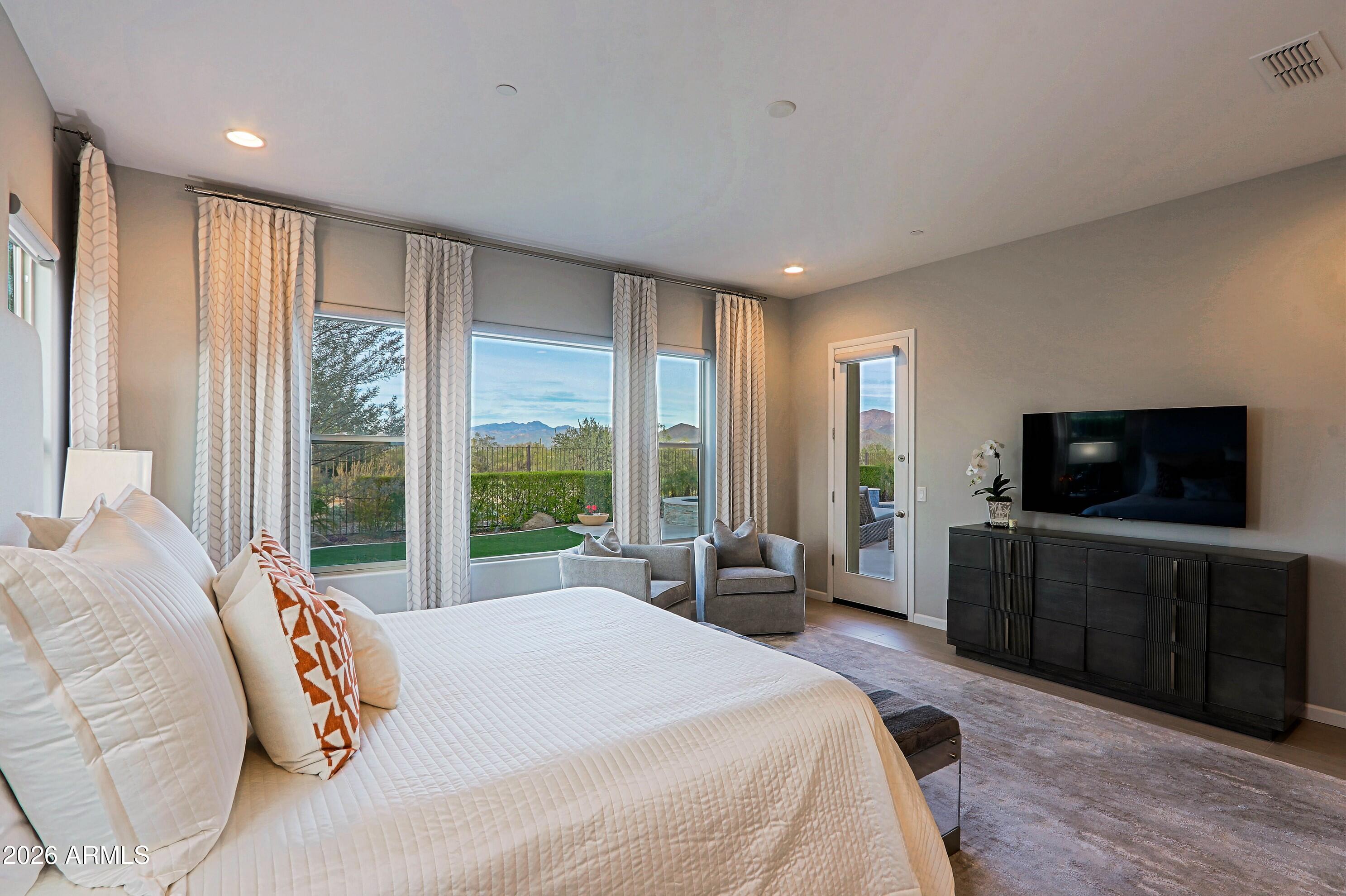 17864 East Paria Canyon Drive Rio Verde, AZ 85263 - Photo 22 of 66 a spacious bedroom with a large bed and a flat screen tv