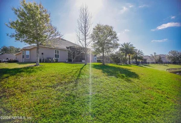 a view of a house with a big yard and large trees