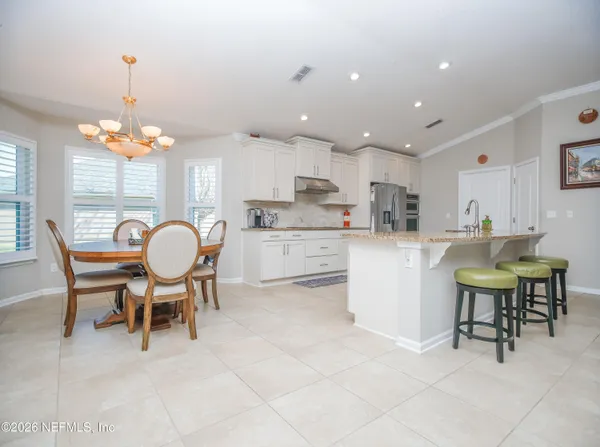 a kitchen with cabinets and chairs